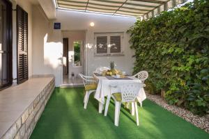 une table et des chaises sur une terrasse avec de l'herbe verte dans l'établissement Cozy apartment Josipa, à Privlaka