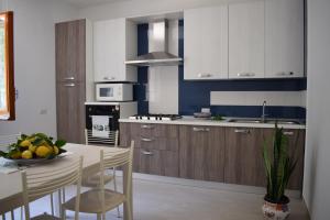 a kitchen with white cabinets and a table with a bowl of fruit at Sorrento Dolce Casa in Sorrento