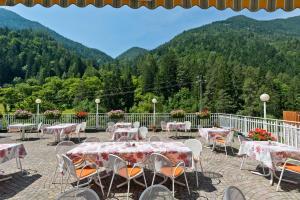 a patio with tables and chairs with mountains in the background at Gasthof Zur Sonne in Cardano