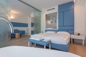 um quarto azul com uma cama e um espelho em Hotel Mediterraneo em Sottomarina