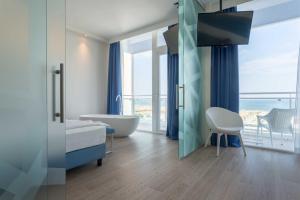 a bathroom with a tub and a sink and a bath tub at Hotel Mediterraneo in Sottomarina