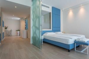 a bedroom with a bed and a glass wall at Hotel Mediterraneo in Sottomarina