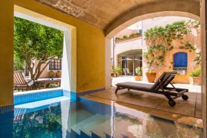 a swimming pool in a house with a chair in the middle at Hotel Can Moragues in Artá