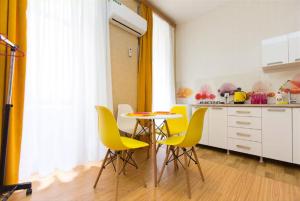 une cuisine avec une table et des chaises jaunes dans l'établissement Pop Art Studio Apartment, à Tbilissi