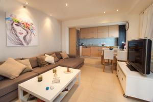 a living room with a couch and a tv at Infinity Beach House in Kefalonia in Argostoli