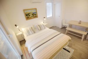 biała sypialnia z łóżkiem i biurkiem w obiekcie Apartments Villa Navi w Bibinje