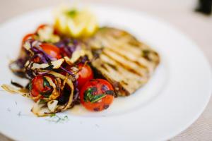 un piatto bianco di cibo con pomodori di Hotel Paradiso a Senigallia