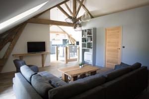 una sala de estar con un sofá y una mesa en La Grange aux Ecureuils, en Levernois