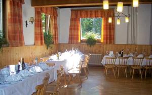 uma grande sala com mesas e cadeiras com toalha de mesa branca em Jugendgästehaus Gosauschmied em Gosau