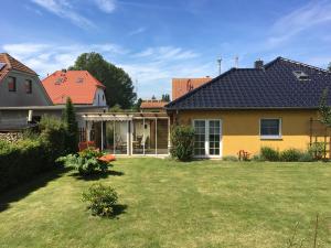 ein Haus mit Rasen im Hof in der Unterkunft Möllis Apartment am Jasmund-Nationalpark in Lohme