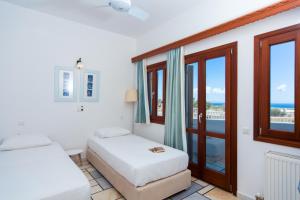Éxo Goniáにあるラ ノイ ハウスのベッドルーム1室(ベッド2台付)、海を望むバルコニーが備わります。