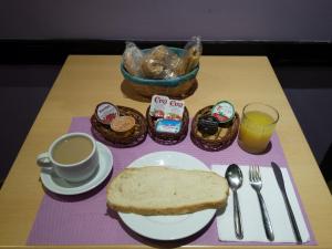a table with a plate of bread and a cup of coffee at Las Abadías in Mérida