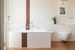 a white bathroom with a sink and a toilet at Hotel Stralsund in Stralsund
