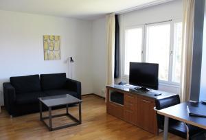uma sala de estar com um sofá e uma televisão em Place Lund Studios em Lund