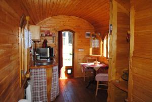 eine Küche und ein Esszimmer in einem Blockhaus in der Unterkunft la Roulotte du Cos in Lamothe-Capdeville