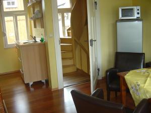 a room with a kitchen and a table and a microwave at Am Kleinsten Haus in Wernigerode