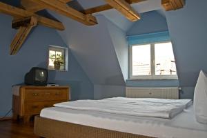 a blue bedroom with a bed and a tv at Am Kleinsten Haus in Wernigerode