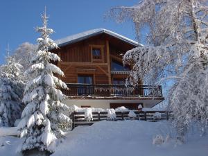 a log cabin with a balcony in the snow at Joly Bois in Crest-Voland