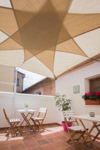 a patio with tables and chairs under a roof at Hostal El Convent de Moncada in Moncada