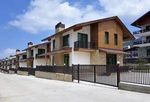 a row of houses with a black fence at Crystal Town House in Bakuriani