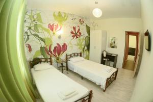 a room with two beds and a floral wall at HotelJet in Domodedovo