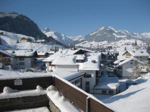 una ciudad cubierta de nieve con montañas en el fondo en Haus Keti, en Riezlern