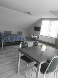 Habitación con mesa, sillas y cama en Guesthouse SiSa, en Veurne