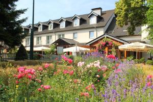 a garden with flowers in front of a building at Hotel und Restaurant Eurohof in Duisburg