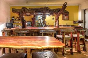 eine Bar mit Holztischen und -stühlen in einem Zimmer in der Unterkunft Trans Kalahari Inn in Voigtland