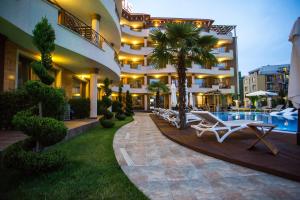 a hotel with a pool and lounge chairs in a courtyard at Boutique Apart Hotel Versis in Sunny Beach