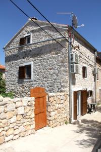 a stone building with a wooden door in front of it at Vacation home Ania in Prvić Luka