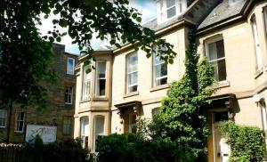 a large brick building with trees in front of it at Albyn Townhouse in Edinburgh