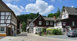 una calle en una ciudad con casas y un coche en Ferienwohnungen Treseburg "Zur Bodehexe", en Thale