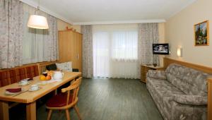 a living room with a couch and a table at Ferienwohnungen Rahm in Mayrhofen