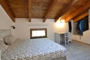 a bedroom with a bed and a desk and a window at Songbird in Agerola
