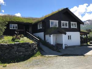 a house with a wooden roof and a stone wall at Granmo Camping in Oppdal