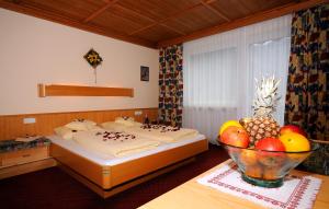a bedroom with two beds and a bowl of fruit on a table at Ferienwohnungen Rahm in Mayrhofen