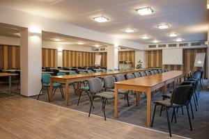 Hotel Šariš في بارديوف: قاعة اجتماعات مع طاولات وكراسي في مبنى