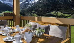 een tafel op een terras met uitzicht op de bergen bij Ahorn Chalet Mittelberg in Mittelberg