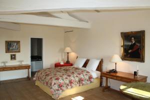 a bedroom with a bed and a painting on the wall at Château du Tertre in Arsac