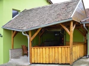 a house with a wooden deck with a roof at Apartment Racing in Beli Manastir