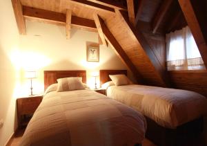 Duas camas num quarto com tectos em madeira em Charming Escarrilla em Escarrilla