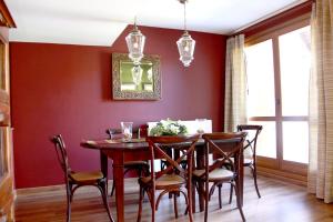 uma sala de jantar com paredes vermelhas e uma mesa e cadeiras de madeira em Charming Escarrilla em Escarrilla