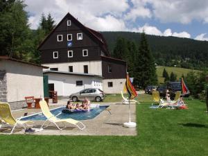 a group of people sitting in chairs in a yard at Hotel Flora Dolní Mísečky in Dolni Misecky