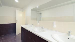 a bathroom with two sinks and two mirrors at Gar'is Hostel Kyiv in Kyiv