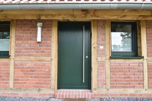 ceglany dom z czarnymi drzwiami i dwoma oknami w obiekcie Gästehaus Verl w mieście Verl