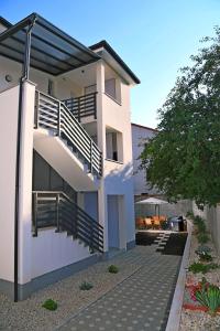 a white building with balconies on the side of it at Apartmani Valis in Matulji