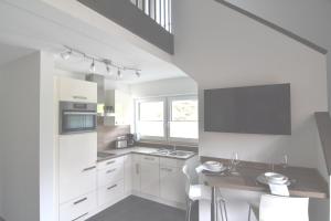 a kitchen with white cabinets and a table at Gästehaus Verl in Verl