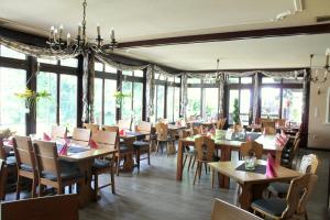 a dining room with tables and chairs and windows at Haus Kastanienhof in Mülheim an der Ruhr