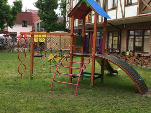 a playground with a slide in a yard at Apartamenty Owocowe in Rowy